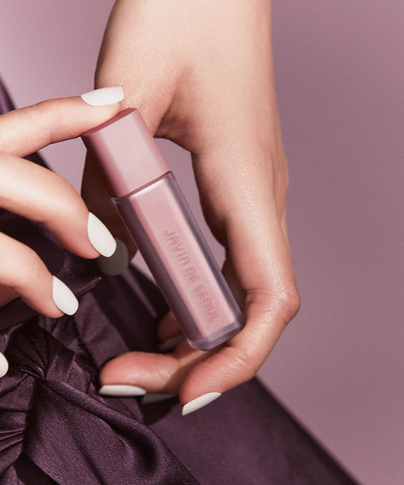 Main tenant le JAVIN DE SEOUL Wink Eye Shade Primer, un primer pour paupières offrant une base lisse et durable pour le maquillage des yeux.