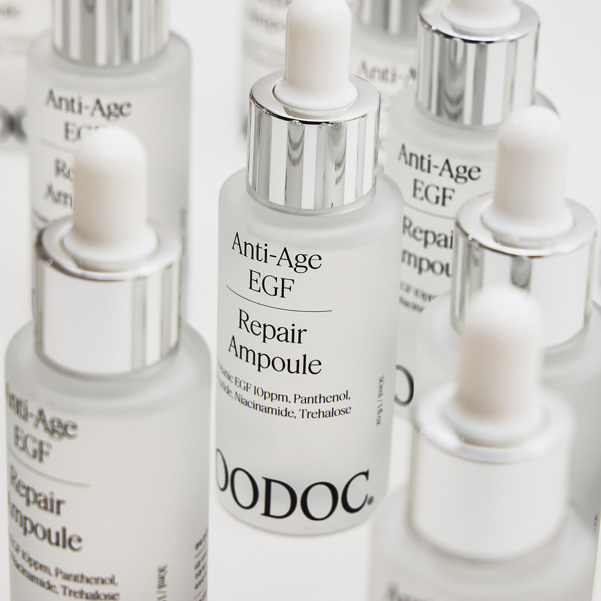 JOODOC Anti-Age EGF Regeneration Super Ampoule 30ml, flacons blancs et argentés sur fond lumineux, produits anti-âge.