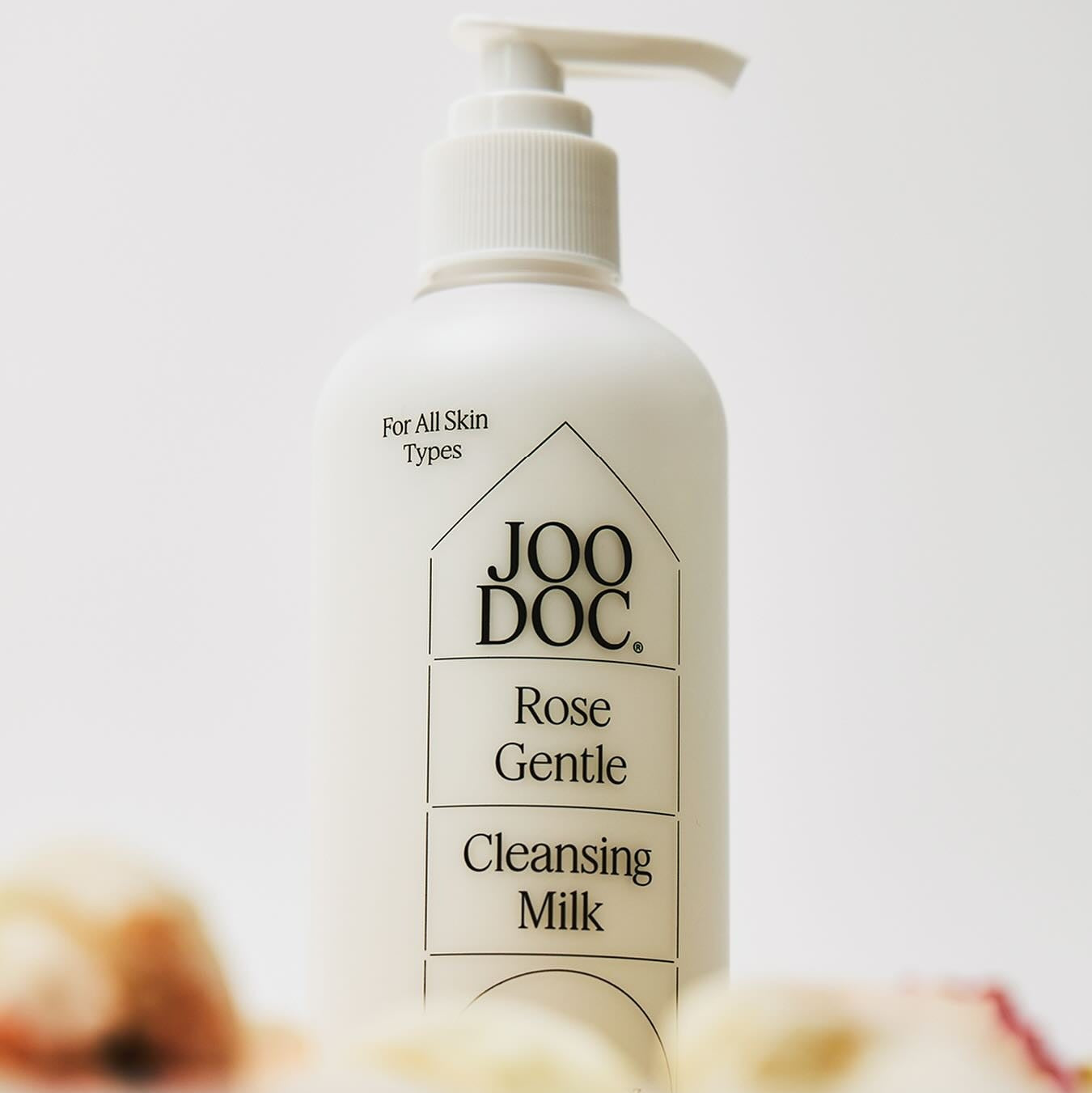 JOODOC  Rose Gentle Cleansing Milk 250ml : lait nettoyant à la rose, flacon pompe sur fond clair, style cosmétique.