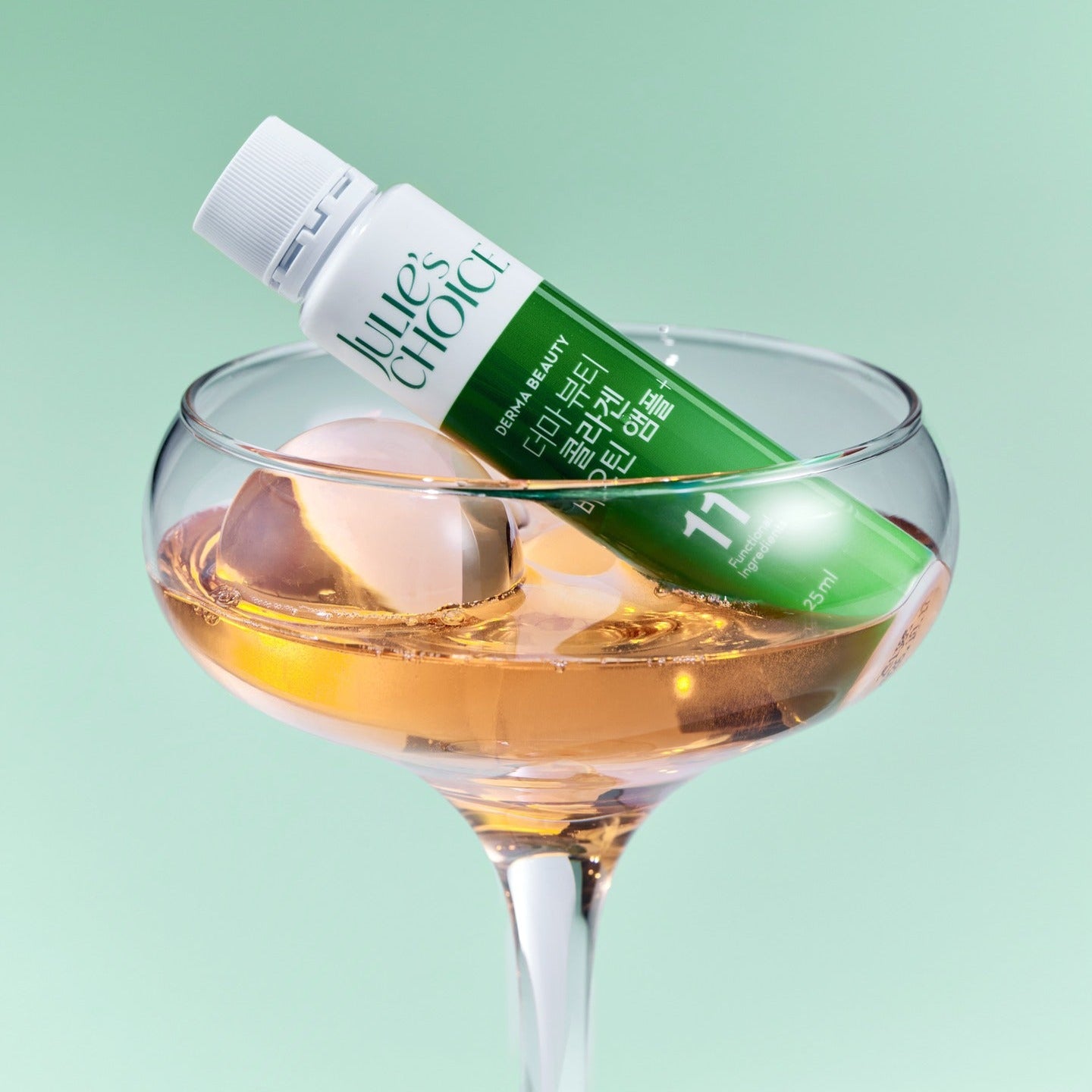 Décris l'image en français : JULIE'S CHOICE Derma Beauty Collagen Biotin Ampoule 25ml, marque en flacon, posé sur fond vert.