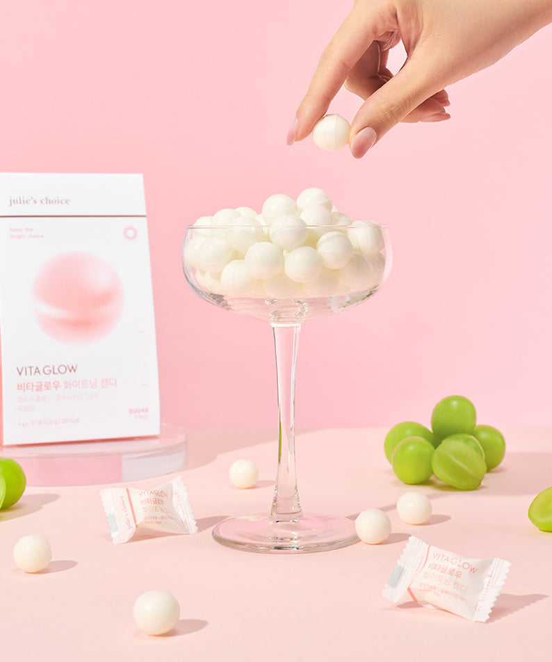 JULIE'S CHOICE Vita Glow Whitening Candy présentée dans une coupe élégante sur fond rose.