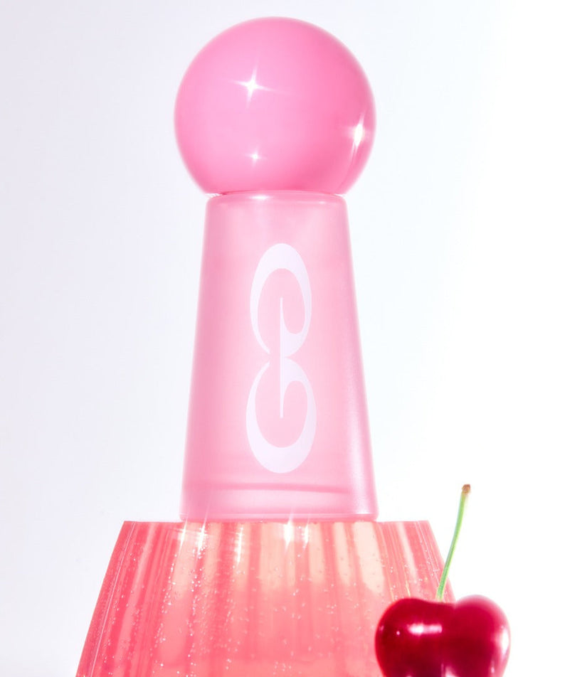 Flacon rose de JULYME Damage Care Perfume Hair Oil 30ml avec cerise à côté, idéal pour soin des cheveux abîmés.