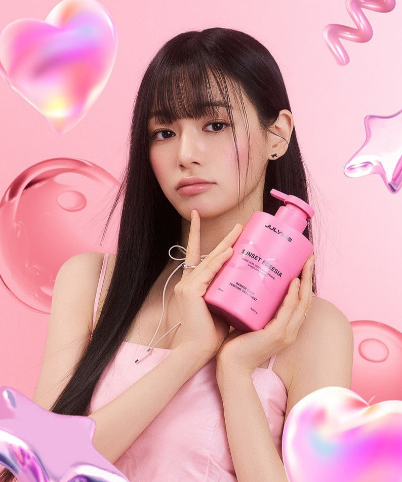 Femme tenant un flacon de JULYME Damage Care Perfume Hair Treatment 500ml sur fond rose avec des éléments fantaisie.