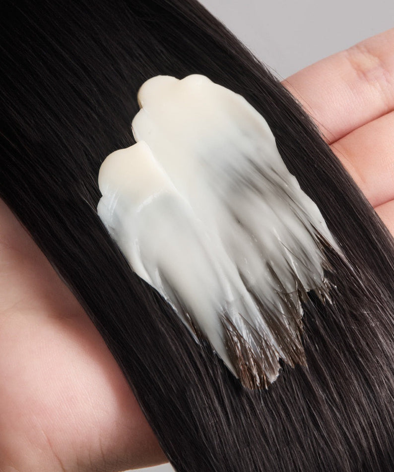 Texture du JULYME Perfume No-Wash Repair Hair Pack 150ml appliqué sur cheveux foncés, illustrant la réparation et l'hydratation instantanées.