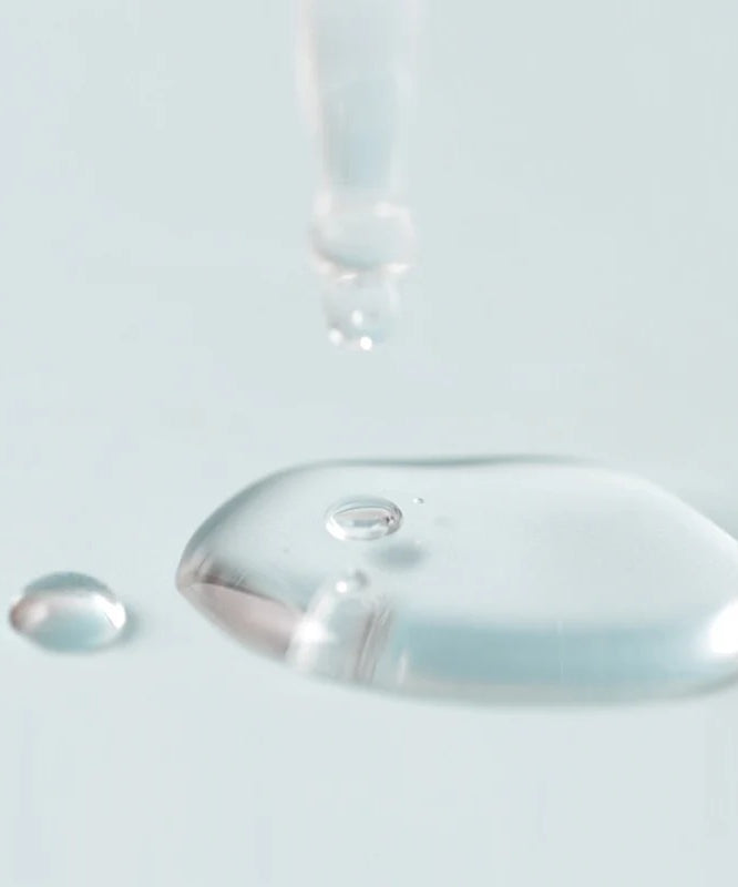 Décris l'image en français en mentionnant le produit, la marque et le contexte visuel : JUMISO D-Panthenol Barrier Soothing Serum 70ml, gouttelette sur flacon bleu pâle.