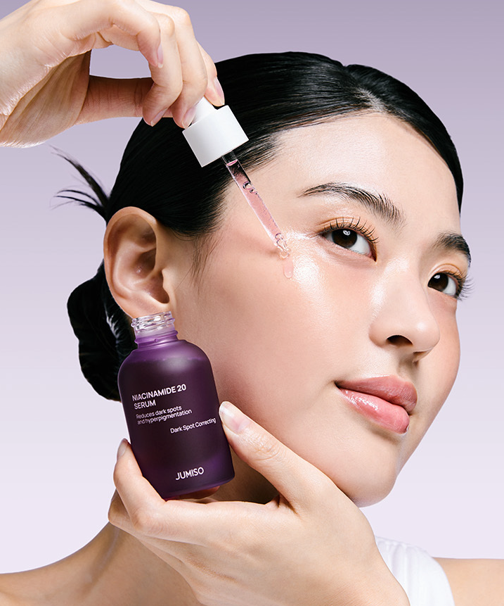 JUMISO Niacinamide 20 Serum 40ml en application sur le visage, main tenant le flacon, contexte beauté en studio