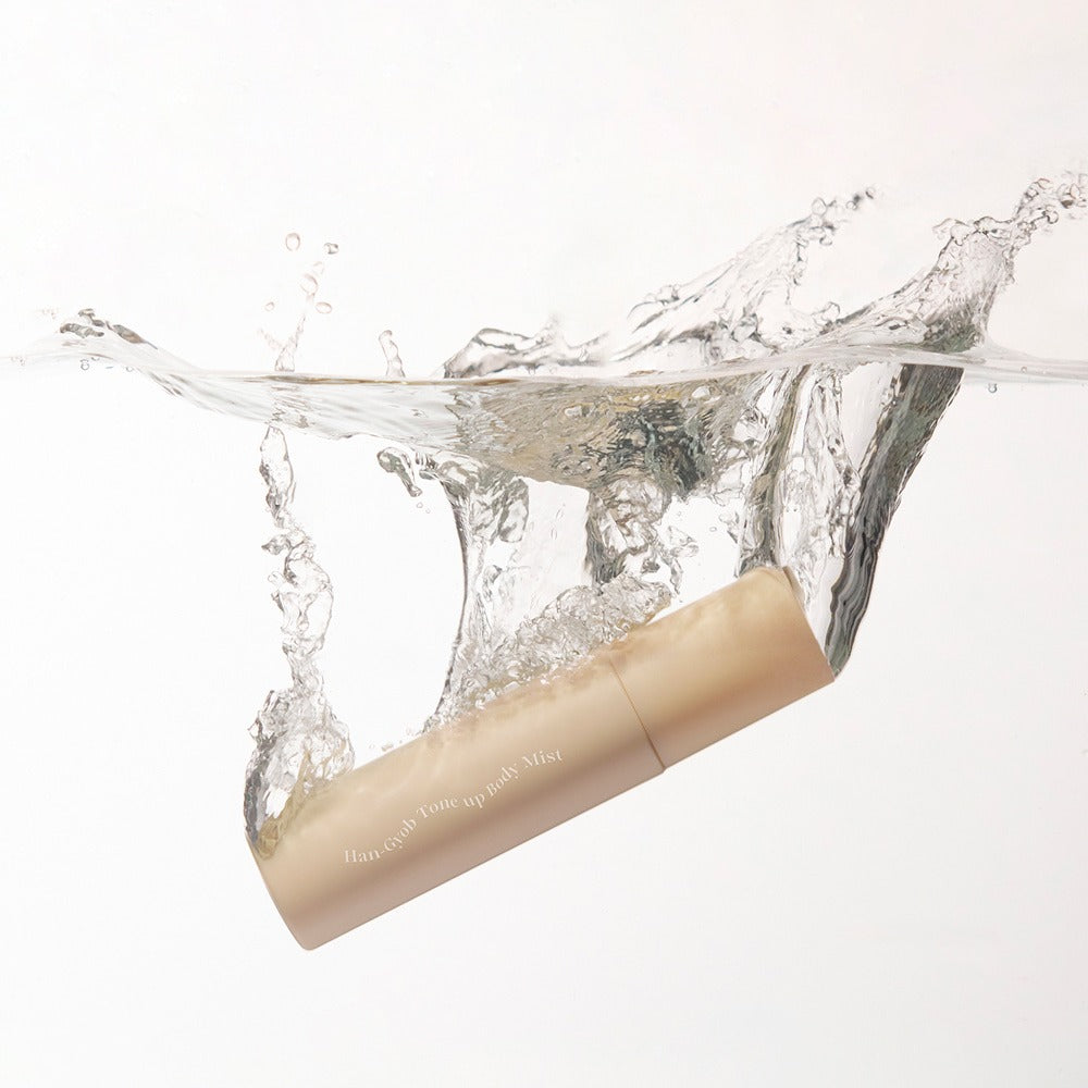 KAHI One Layer Tone-up Body Mist 100ml, brume tonifiante de la marque KAHI, flacon nude dans l’eau qui éclabousse sur fond blanc.