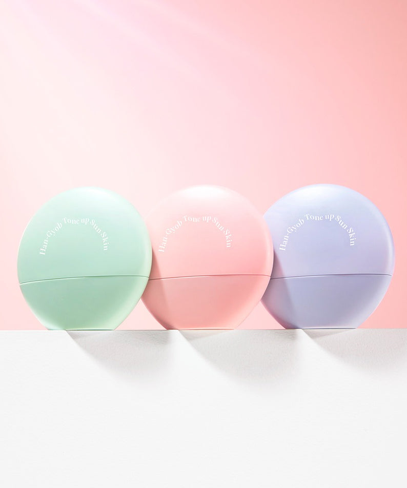 KAHI One Layer Tone-up Sun Skin 40ml de la marque KAHI, flacons pastel sur fond rose, produit cosmétique au soleil