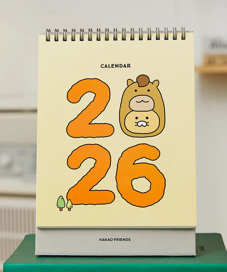 KAKAO FRIENDS Desk Calendar 2026, calendrier de bureau avec design numéro 2026, marque KAKAO FRIENDS en fond de bureau.