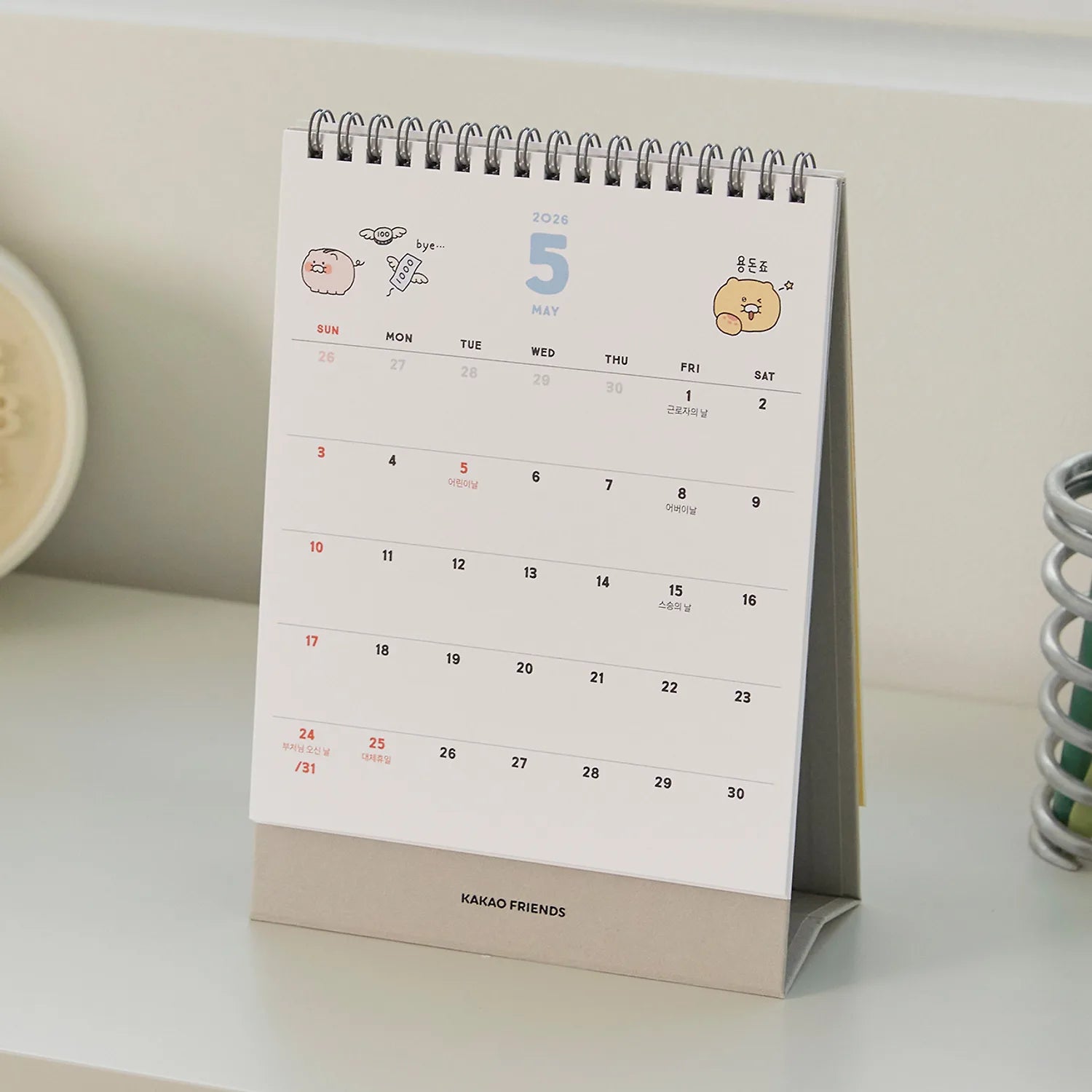 Décris l'image en français : KAKAO FRIENDS Desk Calendar 2026, calendrier de bureau sur un bureau, design mignon.