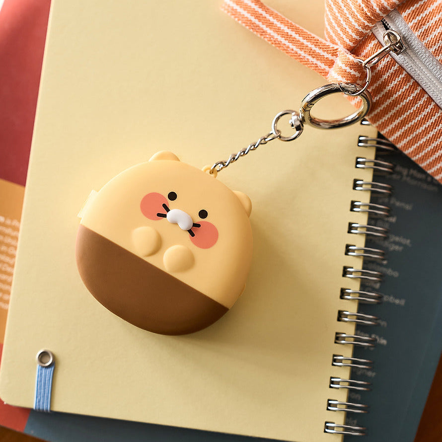 KAKAO FRIENDS Medicine bottle keychain : mini porte-clés en forme de flacon, sur carnet, marque KAKAO FRIENDS en contexte visuel.