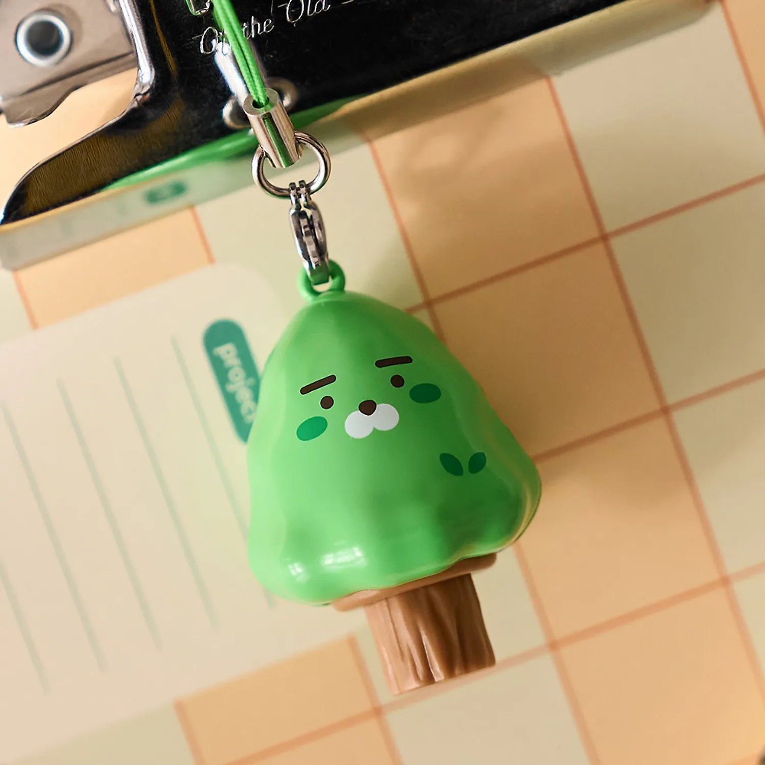 KAKAO FRIENDS Peekaboo Moving Keyring : porte-clés à l’effigie de KAKAO FRIENDS vert, sur carrelage, mouvement visible, marque.