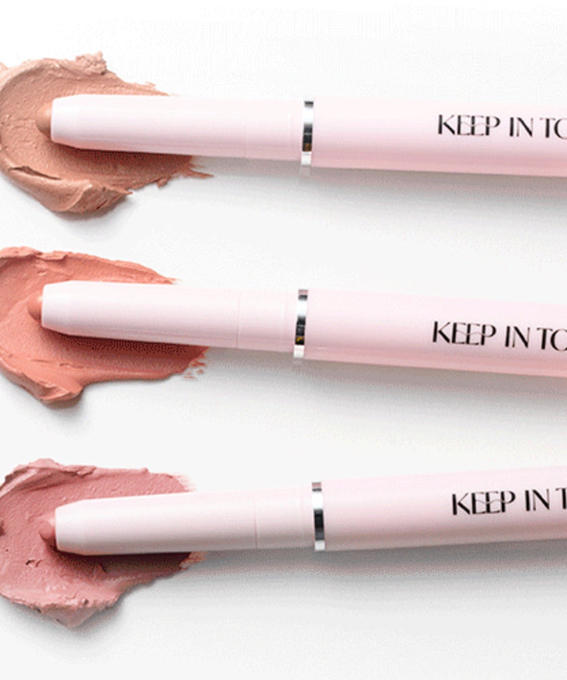 Stylos KEEP IN TOUCH Glow Lip Sealer Pencil avec nuances de maquillage rose sur une surface blanche.