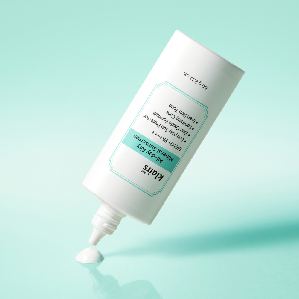 KLAIRS  All Day Airy Invisible Tone-Up Sunscreen 60g (SPF50+ PA++++), tube crème blanc sur fond bleu ciel.