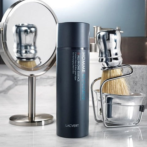LACVERT  Homme Recharge All-in-One Essence 150ml : flacon bleu sur coiffeuse, rasage et miroir, ambiance salle de bain.
