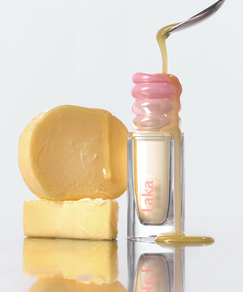 LAKA Maxi Glare Tint, marque LAKA : sérum brillant avec goutte dorée, flacons et savon, fond blanc.
