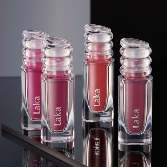LAKA Maxi Glare Tint de la marque LAKA, tubes brillants sur présentoir, visuel maquillage en dégradé rose et rouge