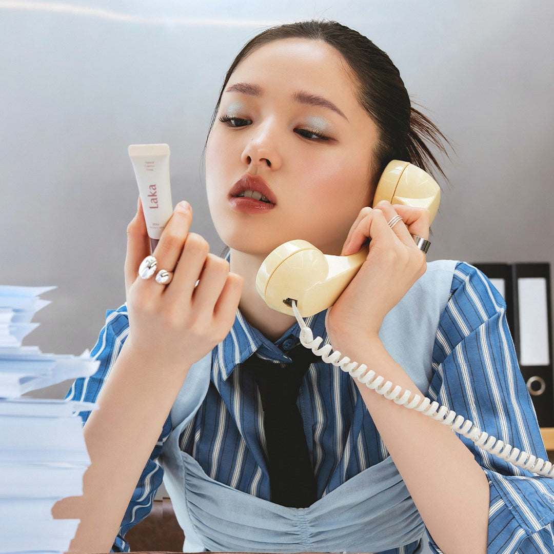 Décris l'image en français: LAKA Pixi Brow Cara 8g de la marque LAKA, maquillage des sourcils, en main, au bureau.