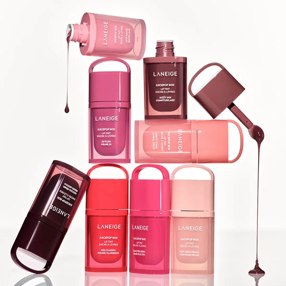 Décris l'image en français : LANEIGE Juice Pop Box Lip Tint 4.5g, coffret de lip tint roses, marque sur flacons, fond blanc.
