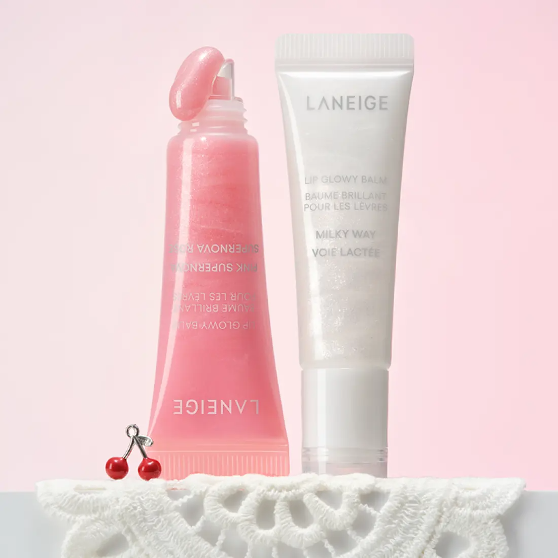 LANEIGE Lip Glowy Balm (Milky Way/Pink Supernova) 10g, baume lèvres rose; flacon et tube sur fond pastel, style dessert
