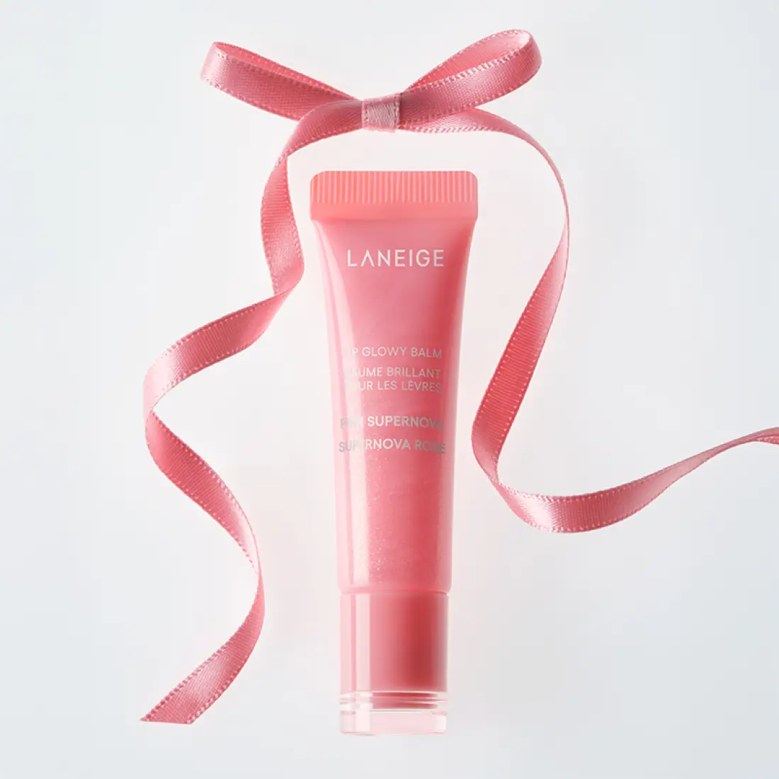 Décris l'image en français en mentionnant le produit, la marque et le contexte visuel : LANEIGE Lip Glowy Balm (Milky Way/Pink Supernova) 10g