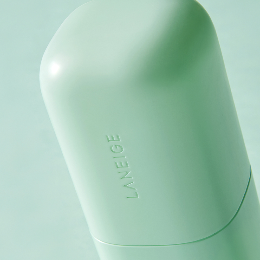 Décris l'image en français en mentionnant LANEIGE Skin Veil Base SPF28/PA++ 30ml, pot vert clair, pack beauté sur fond pastel.