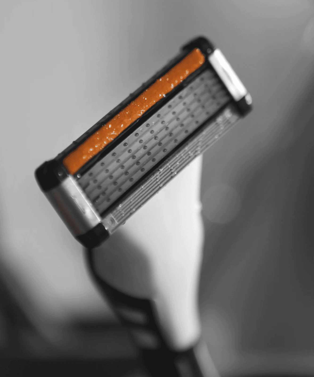 LAZY SOCIETY Shaving Set 8 Pieces : rasoir orange et noir de la marque, gros plan sur accessoires dans une salle de bain