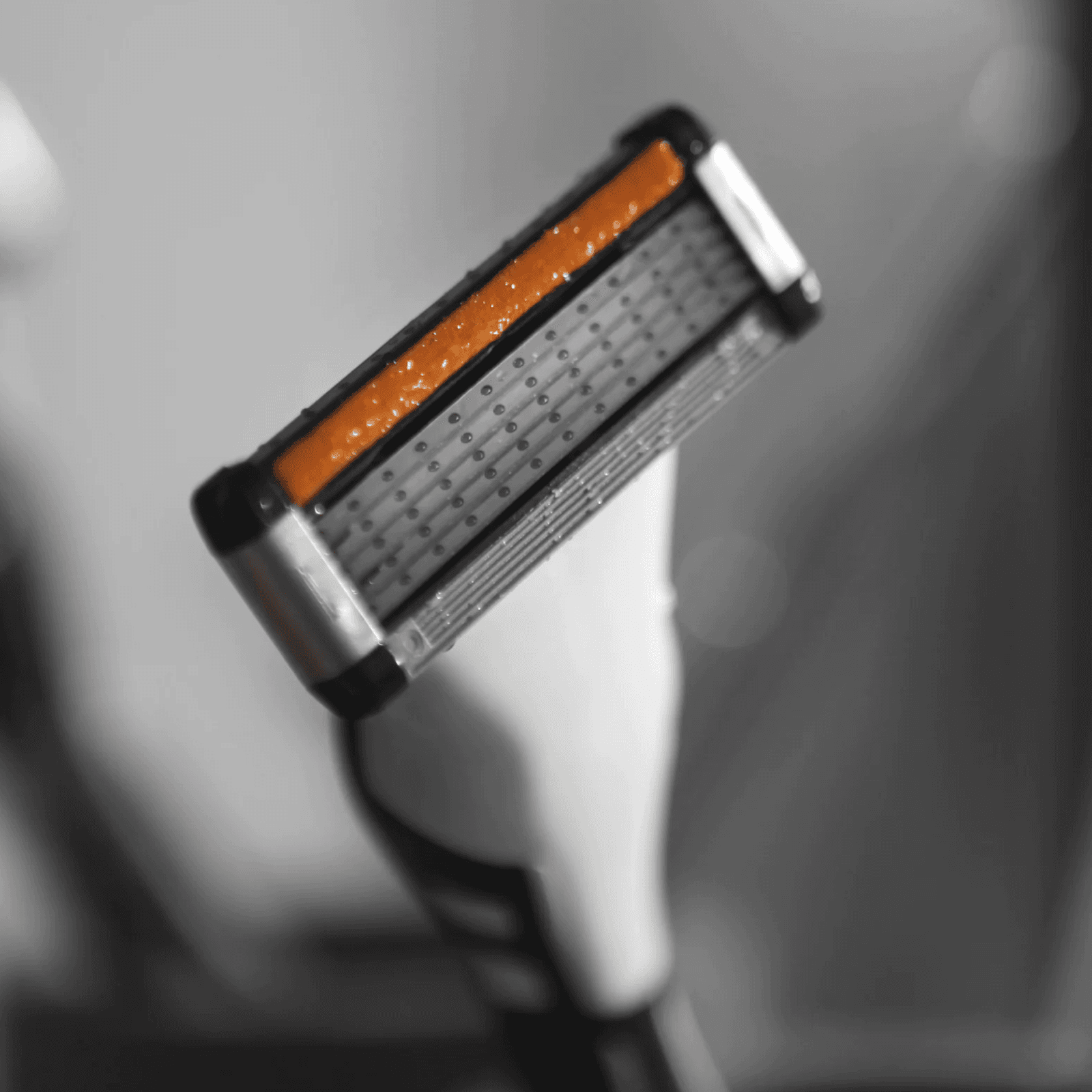 LAZY SOCIETY Shaving Set 8 Pieces : rasoir orange et noir de la marque, gros plan sur accessoires dans une salle de bain