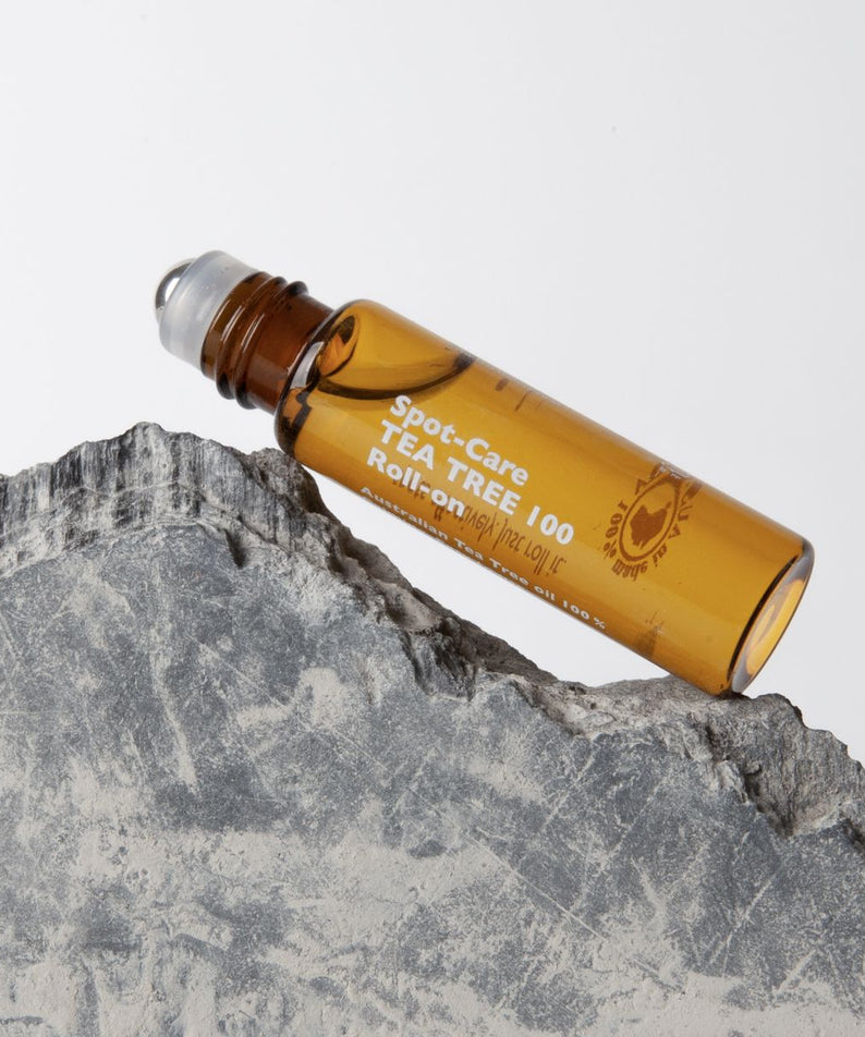 LAZY SOCIETY Spot Care Tea Tree 100 Roll on 5.5ml, roll-on sur pierre grise, produit et marque bien visibles, contexte soin