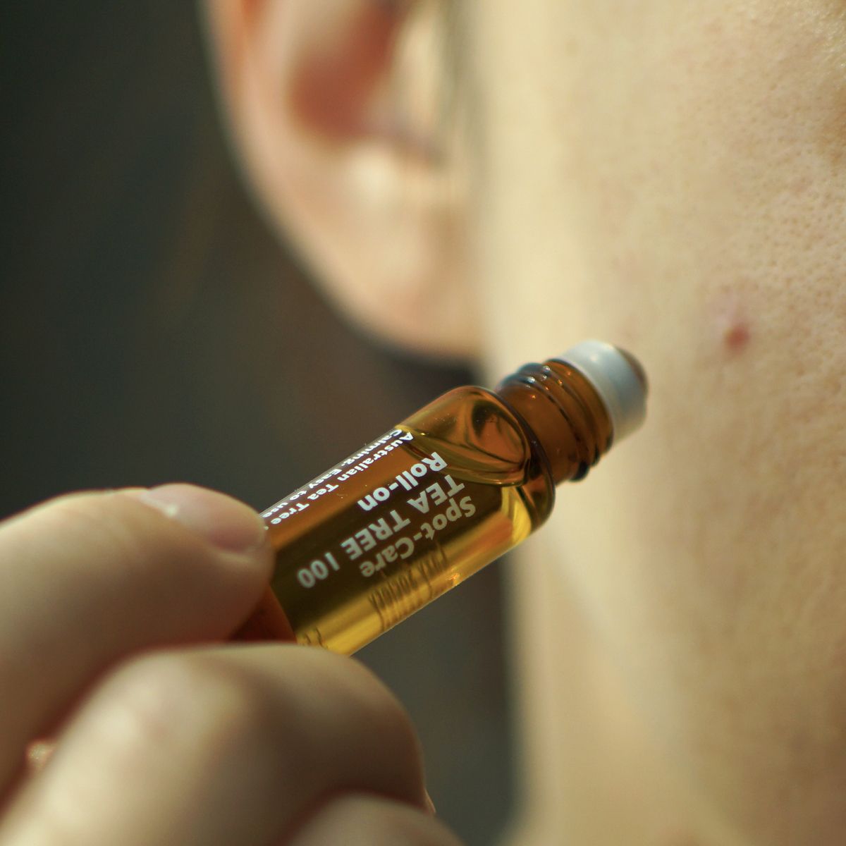 LAZY SOCIETY Spot Care Tea Tree 100 Roll on 5.5ml, huile anti-imperfections au tea tree, appliquée sur peau, gros plan.