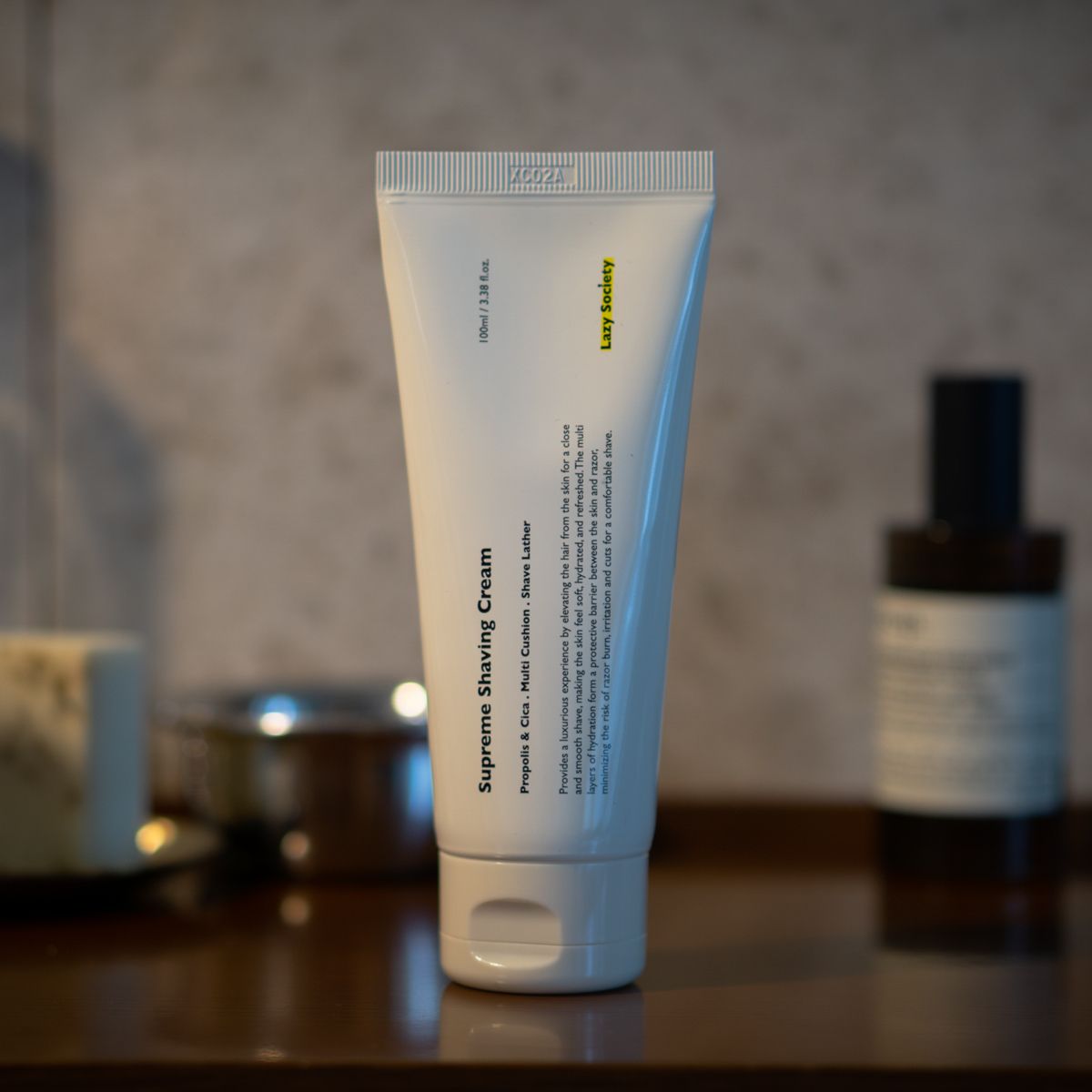 LAZY SOCIETY Superme Shaving Cream 100ml, crème à raser visible sur fond salle de bain, marque en gros plan.