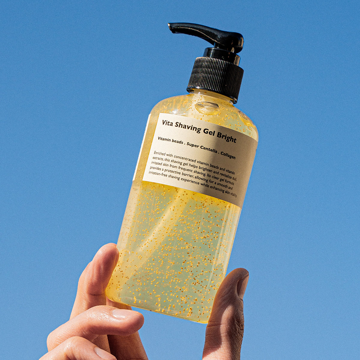 LAZY SOCIETY Vita Shaving Gel Bright 250ml en flacon à la main sur fond bleu, produit cosmétique en contexte visuel.