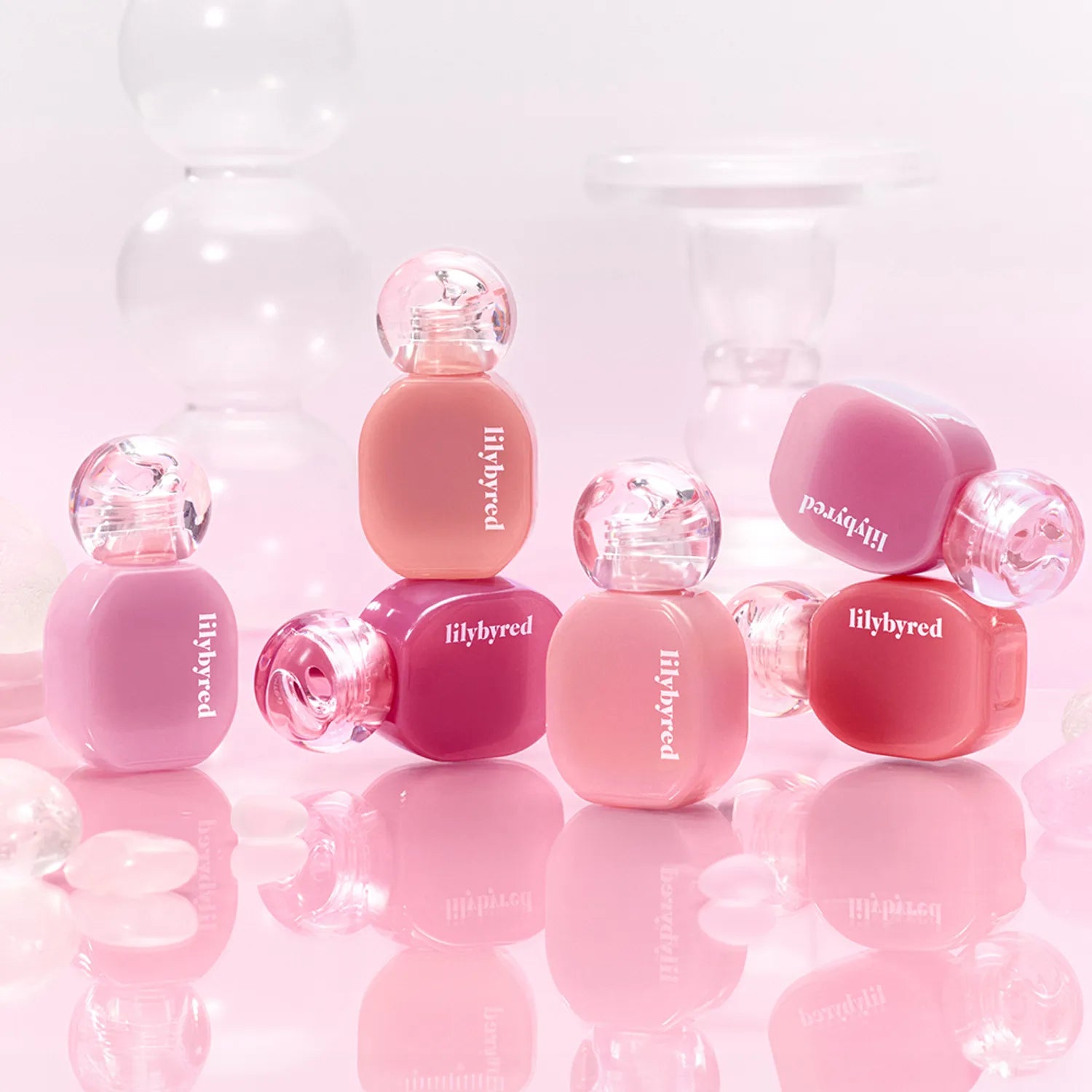 LILYBYRED Balming Dewy Tint de la marque LILYBYRED, flacons roses dans un décor lumineux et dégradé rose