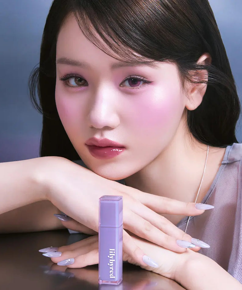 LILYBYRED Bloody Coating Tint, marque LILYBYRED : femme aux lèvres roses, produit sur fond bleu, maquillage en gros plan.
