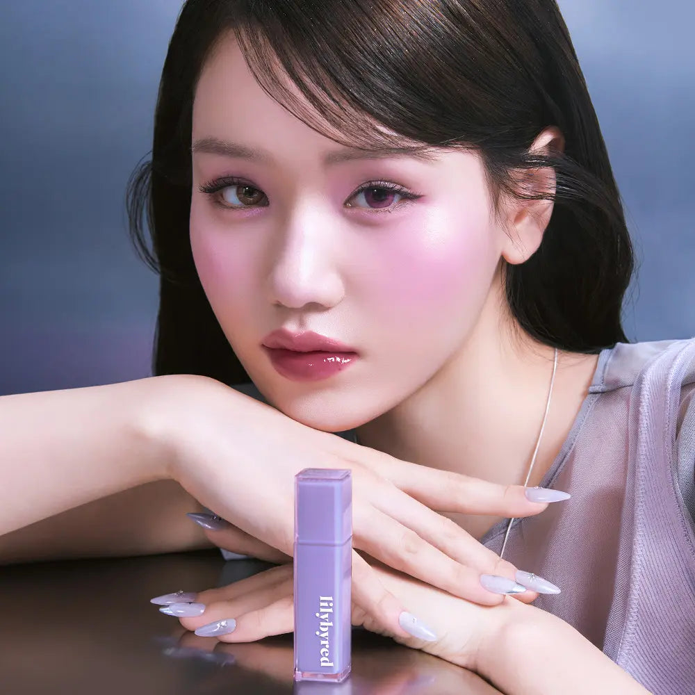 LILYBYRED Bloody Coating Tint, marque LILYBYRED : femme aux lèvres roses, produit sur fond bleu, maquillage en gros plan.
