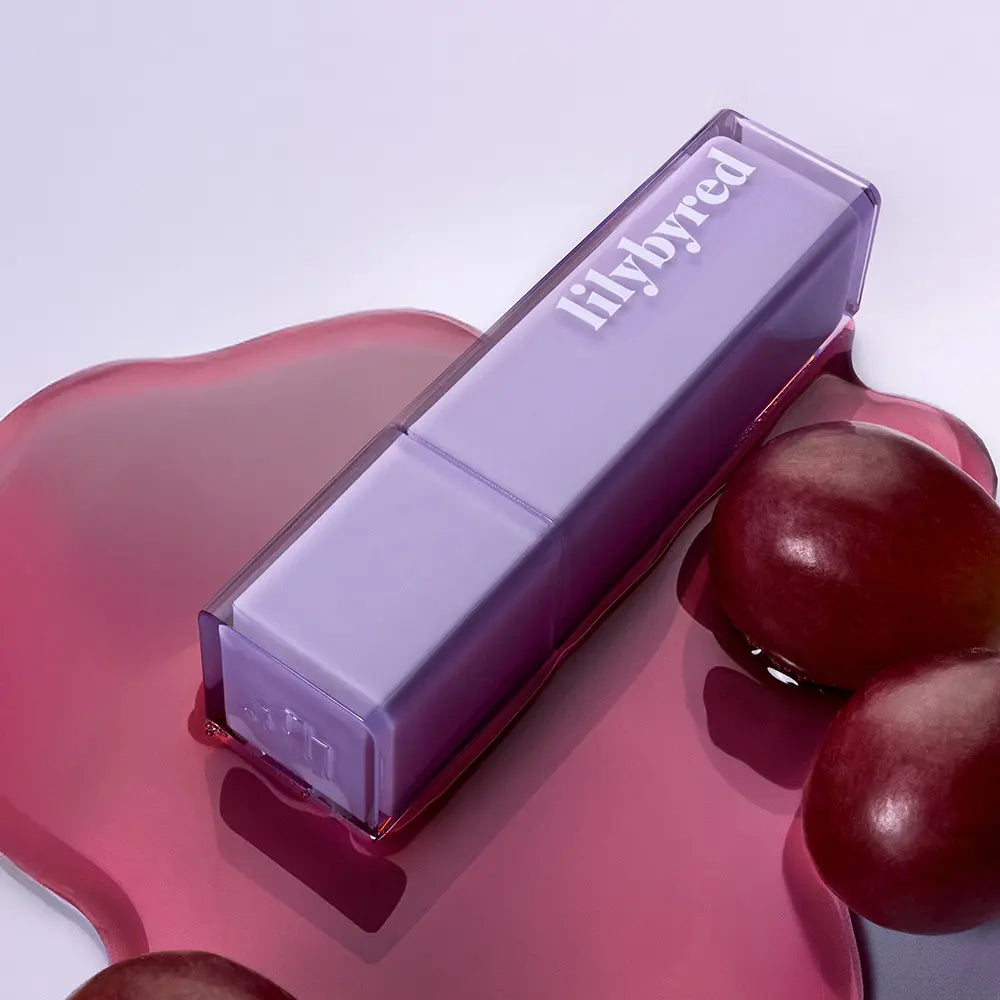LILYBYRED Bloody Coating Tint de la marque LILYBYRED, tube violet sur fond rose avec gouttes rouges, visuel maquillage.
