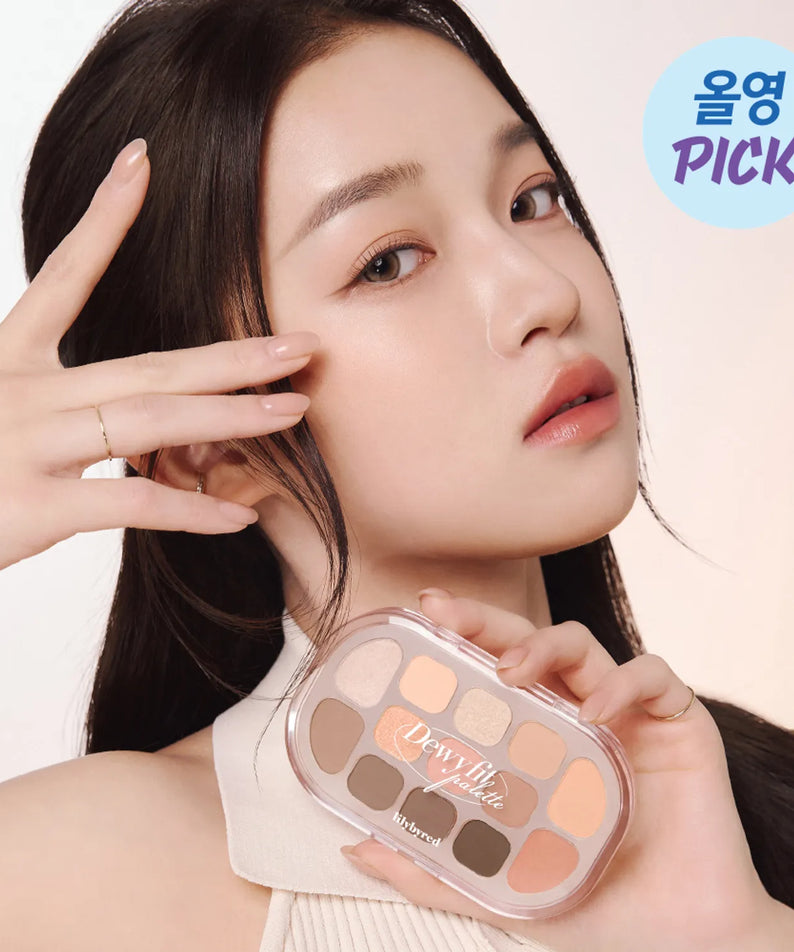 Décris l'image en français : LILYBYRED Dewy Fit Palette, maquillage délavé sur une femme tenant la palette, fond clair.