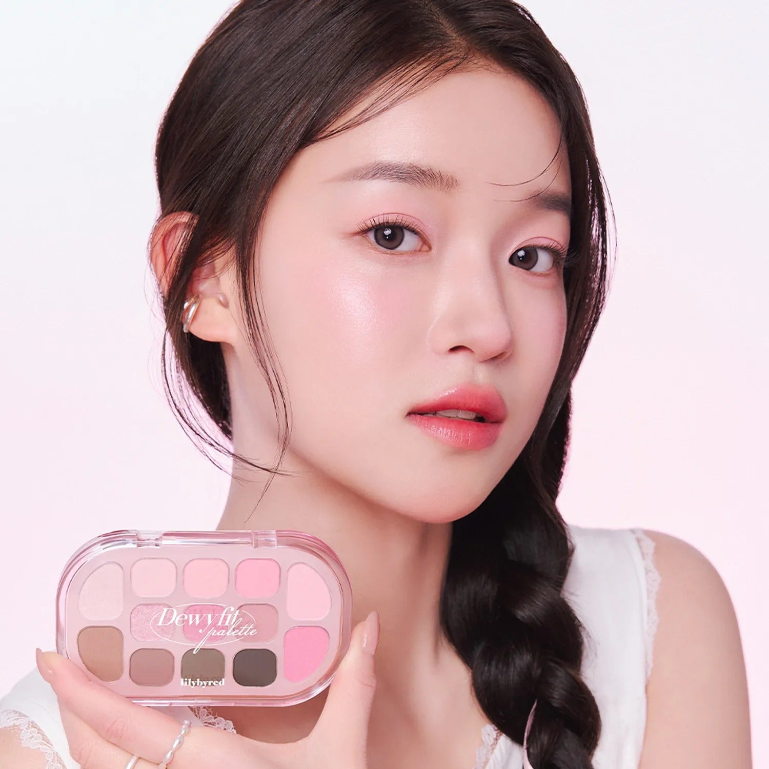 Portrait beauté avec LILYBYRED Dewy Fit Palette de la marque, maquillage lumineux, fond clair, modèle tenant la palette.