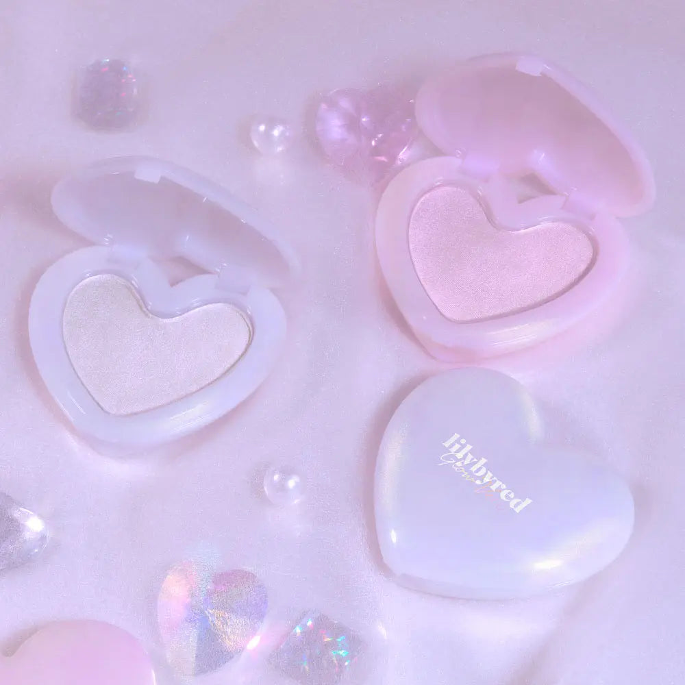 LILYBYRED Love Beam Glow Veil, marque LILYBYRED : éclats de lumière, coeurs brillants sur fond rose pastel, maquillage