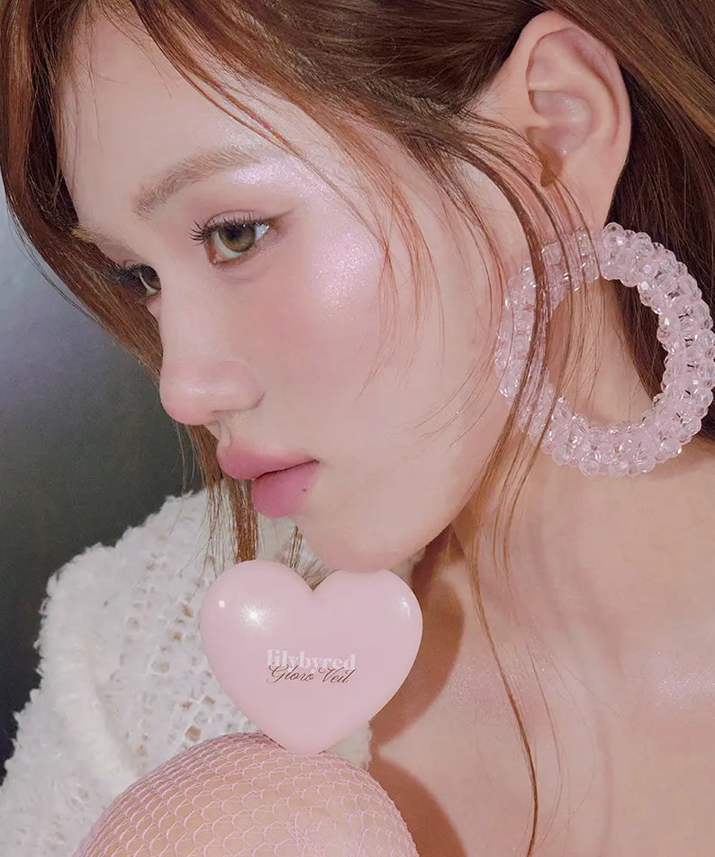 LILYBYRED Love Beam Glow Veil sur visage lumineux, gros plan maquillage avec cœur et accessoires, marque LILYBYRED, ambiance douce