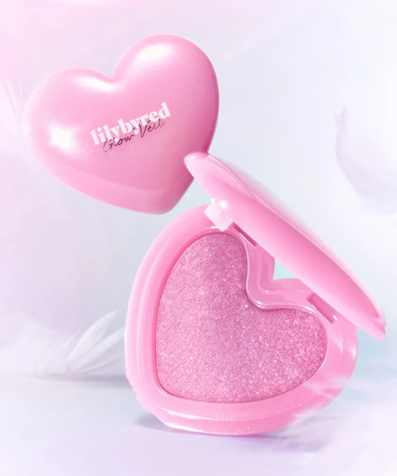 LILYBYRED Love Beam Glow Veil de la marque, packaging cœur rose, éclat lumineux sur fond clair, produit maquillage