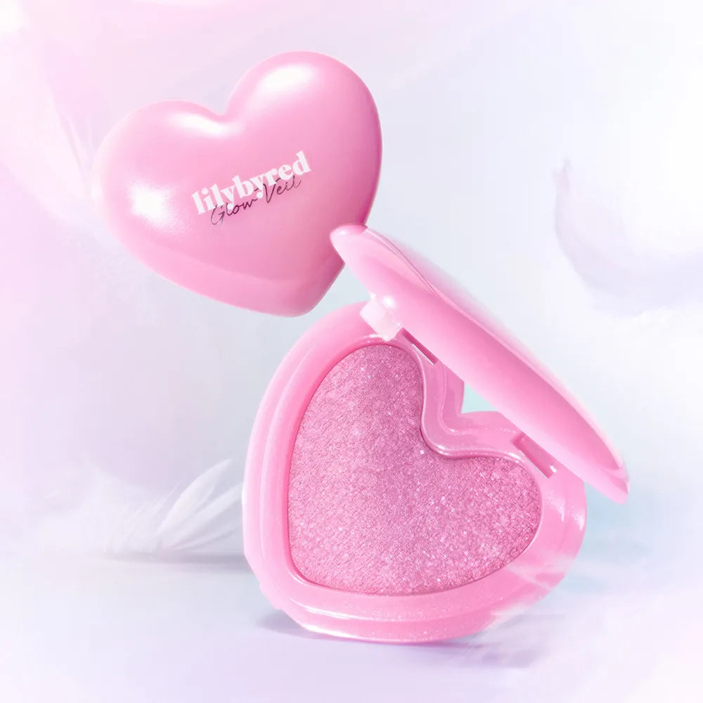 LILYBYRED Love Beam Glow Veil de la marque, packaging cœur rose, éclat lumineux sur fond clair, produit maquillage
