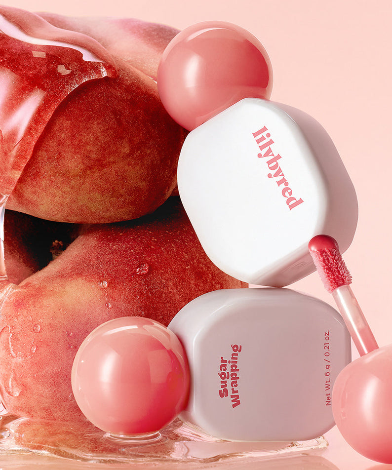 LILYBYRED Sugar Wrapping Tint Gloss de la marque LILYBYRED, gloss lèvres rose sur fond pastel, rendu sucré (packshot)