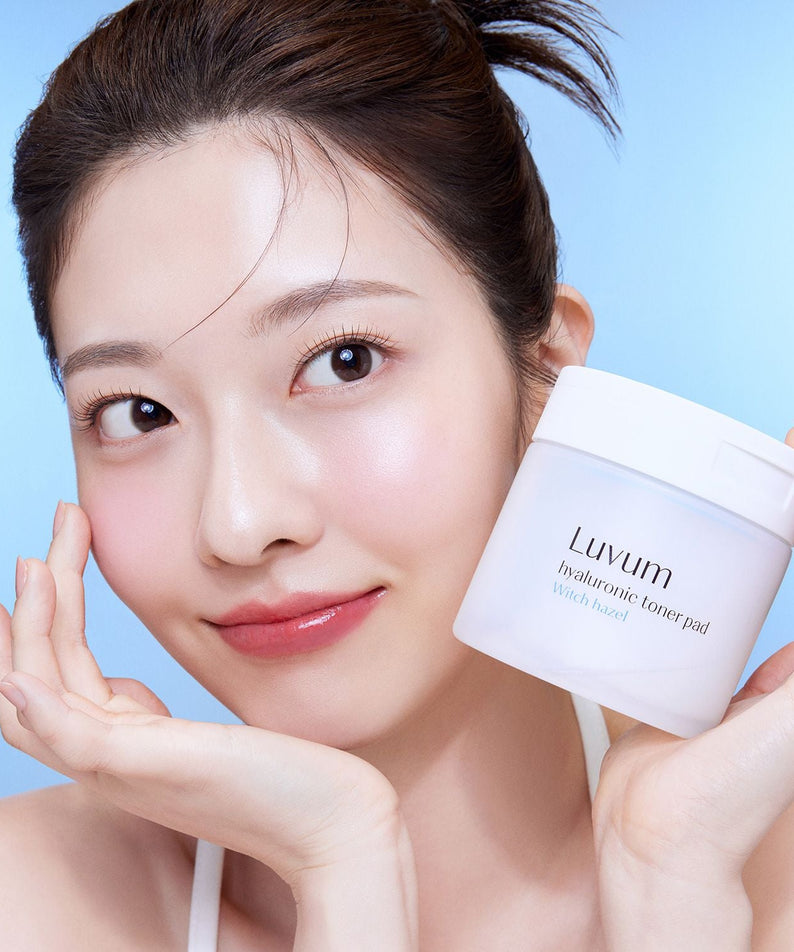 LUVUM 1 Hyaluronic Acid Toner Pads 60 Sheets : femme au visage lissant tenant le pot sur fond bleu