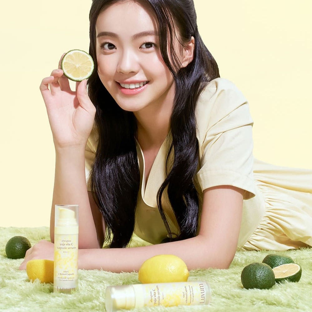 LUVUM After Glow Yuja Vita C Capsule Serum 30ml : flacon sur fond vert, jeune femme souriante tenant un citron, marque LUVUM