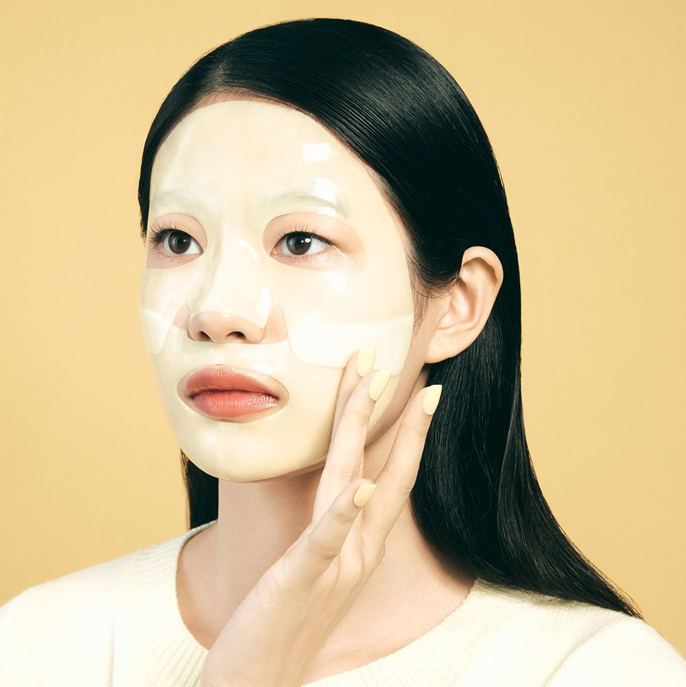 LUVUM Afterglow Yuzu Gel Mask 5 Sheets : femme applique un gel masque yuzu, marque LUVUM, soin visage en studio.
