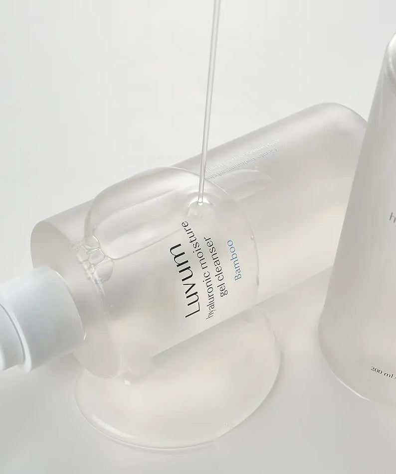 Décris l'image en français : LUVUM Bamboo Hyaluronic Acid Moisture Gel Cleanser 200ml de LUVUM sur flacon blanc en salle de bain.