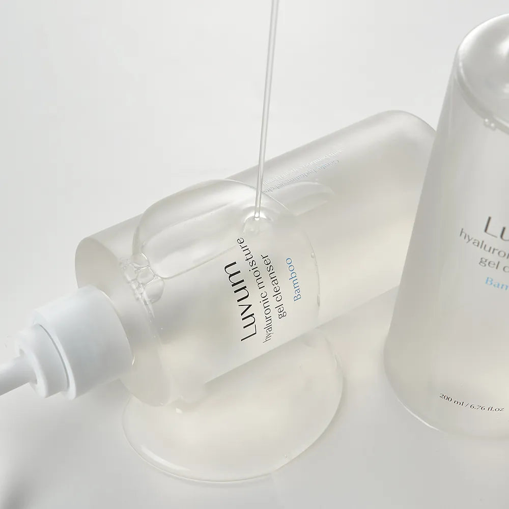 Décris l'image en français : LUVUM Bamboo Hyaluronic Acid Moisture Gel Cleanser 200ml de LUVUM sur flacon blanc en salle de bain.
