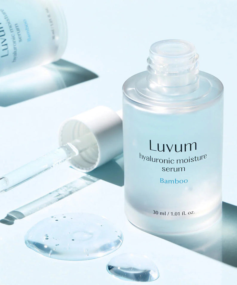 Décris l'image en français : LUVUM Bamboo Hyaluronic Acid Moisture Serum 30ml, flacon bleu sur fond lumineux, gouttes et seringue.