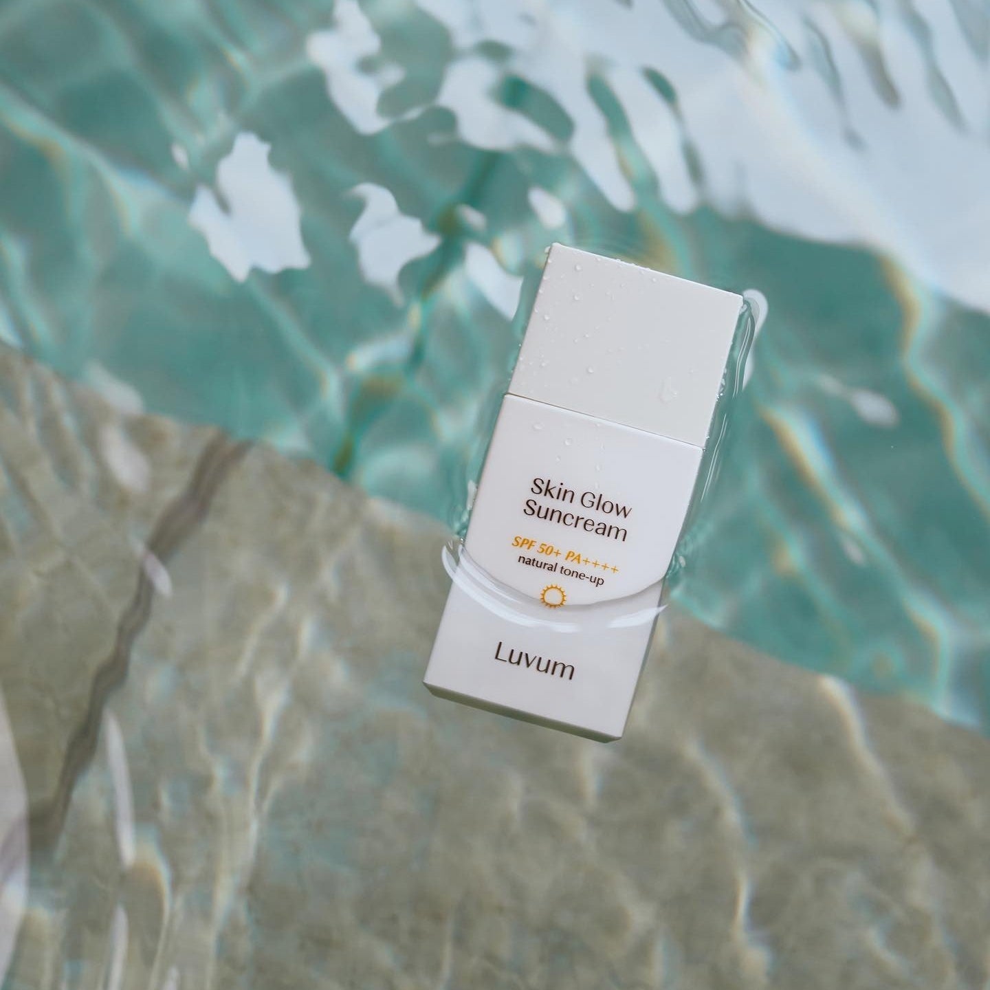 LUVUM Bamboo Hyaluronic Acid Moisture Sunscreen 30ml, crème solaire Luvum au bord d’une piscine, emballage sur l’eau, nature